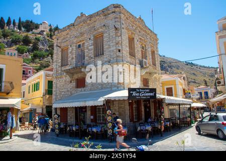 SYMI, Griechenland - 03. JUNI 2021. Ein Grillhaus Restaurant Symi Stadt in der Nähe des Hafens, wo Touristen verweilen. Das schönste und romantischste Viertel im Ganzen Stockfoto