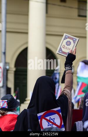 Eine muslimische Frau trägt einen Hijab mit einer abgebrochenen israelischen Flagge, während sie während der Maikundgebung einen Koran hält. Pro-palästinensische Demonstranten nehmen an der Maikundgebung Teil, um durch die Straßen des zentralen Geschäftsviertels von Melbourne in Richtung Victorian Trades Hall zu marschieren. Die politische Kundgebung wurde von Free Palestine Melbourne organisiert. Tausende von Menschen marschierten gegen die Mittäterschaft der Regierung am Völkermord und schlossen sich Gewerkschaften, kommunistischen, sozialistischen und anarchistischen Parteien zu einer Maifeier-Kundgebung an. (Foto: Alexander Bogatyrev/SOPA Images/SIPA USA) Stockfoto