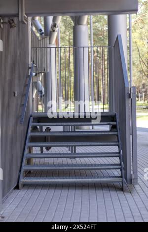 Metalltreppen an der Seite des Gebäudes mit Steinpflaster Stockfoto