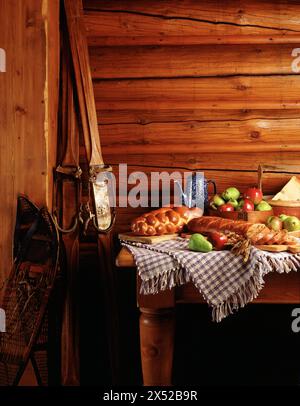 Frühstück mit Käse, frischem Obst, hausgemachtem Brot und Kaffee in rustikalem Blockskichalet. Stockfoto