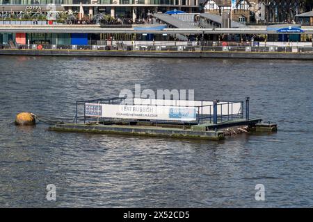 Ein „Müllsammler („I eat Waste“)-Ponton im Hafen von London sammelt schwimmende Abfälle in der Themse, London, Vereinigtes Königreich. Stockfoto