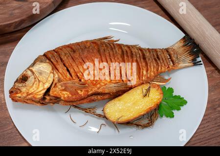 Gebratener Kruzifisch auf Holztisch garniert mit Kartoffeln. Stockfoto