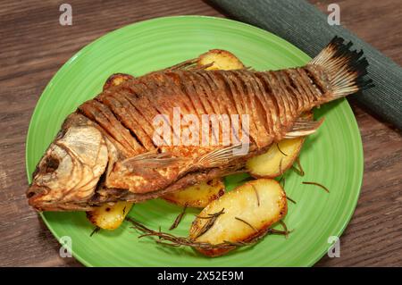 Gebratener Kruzifisch auf Holztisch garniert mit Kartoffeln. Stockfoto