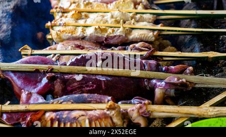 Backen und Grillen von mariniertem Fisch auf einem Grill (gegrillter Fisch). Fisch über Holzkohle gegrillt Stockfoto