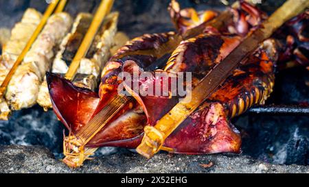 Backen und Grillen von mariniertem Fisch auf einem Grill (gegrillter Fisch). Fisch über Holzkohle gegrillt Stockfoto