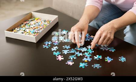 Ältere Frau Hände tun Puzzle closeup Stockfoto