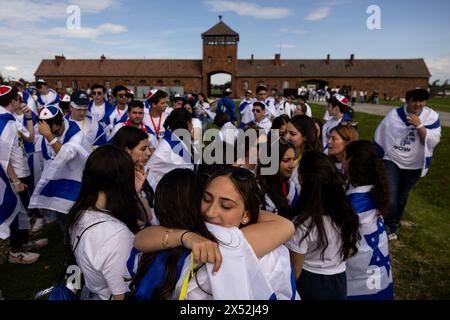 Oswiecim, Polen. Mai 2024. In israelische Flaggen gehüllt, teilen sich die Teilnehmer während des jährlichen „Marsches der Lebenden“, einer Wanderung zwischen zwei ehemaligen von den Nazis betriebenen Vernichtungslagern in Oswiecim und Brzezinka, Polen, eine Umarmung. Die jährliche Veranstaltung erinnert an den Holocaust-Gedenktag und in diesem Jahr ist auch der 80. Jahrestag der nahezu vollständigen Vernichtung der ungarischen jüdischen Gemeinde während des Zweiten Weltkriegs. (Kreditbild: © Maciek Jazwiecki/ZUMA Press Wire) NUR REDAKTIONELLE VERWENDUNG! Nicht für kommerzielle ZWECKE! Stockfoto