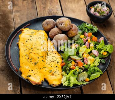 Gebratene Forelle in Zwiebelsauce gebadet - Gemüsesalat mit gebackenen Kartoffeln Stockfoto