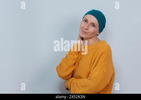 Selbstbewusst aussehende junge Frau mit Hut, die schwere Krankheiten herausfordert Stockfoto