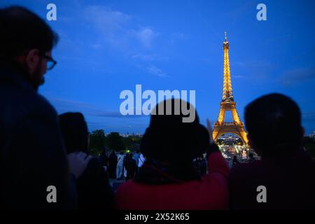 Paris, Frankreich. Mai 2024. Touristen stehen am Abend vor dem Eiffelturm. Die Olympischen Spiele und Paralympics finden im Sommer in Frankreich statt. Robert Michael/dpa/Alamy Live News Stockfoto
