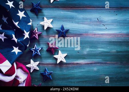 Hintergrund vom 4. Juli. Amerikanische Flagge und rote, weiße und blaue Sterne über einem rustikalen, farbenfrohen Holztisch zum Unabhängigkeitstag. Stockfoto