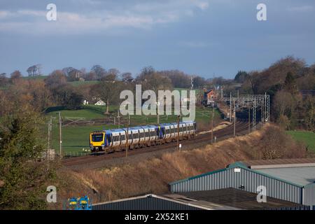 2 Dieseltriebwagen der Northern Rail Class 195 CAF 195124 + 195123 auf der elektrifizierten Hauptstrecke der Westküste in Lancashire durch die Landschaft Stockfoto