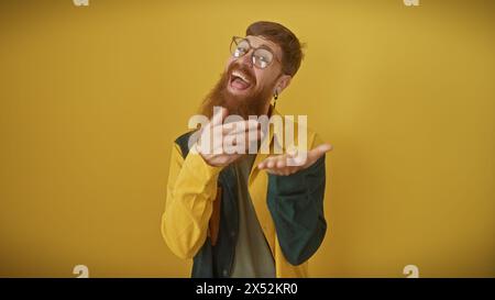 Bärtiger junger Mann in Brille, der fröhlich vor gelbem Hintergrund lacht Stockfoto
