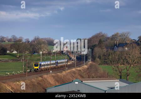 2 Dieseltriebwagen der Northern Rail Class 195 CAF 195124 + 195123 auf der elektrifizierten Hauptstrecke der Westküste in Lancashire durch die Landschaft Stockfoto