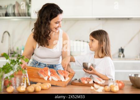 Mom und Tochter bereiten ein festliches Lachsgericht vor. Stockfoto