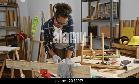 Eine geschickte Zimmerfrau arbeitet fleißig in einer gut ausgestatteten Werkstatt, umgeben von Werkzeugen und Holz. Stockfoto