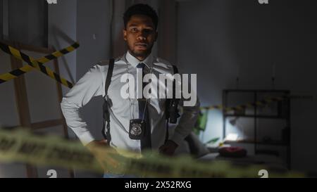 Gutaussehender Mann mit Abzeichen im dunklen Tatortsraum, Polizist-Konzept. Stockfoto