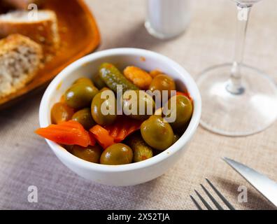 Leichter Snack – ovale Schüssel mit eingelegtem Gemüse, Gurke und grünen Oliven Stockfoto