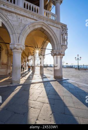 Kolonnade des Dogenpalastes mit Sonnenstern auf der Piazetta San Marco, Markusplatz, Venedig, Venetien, Italien Stockfoto