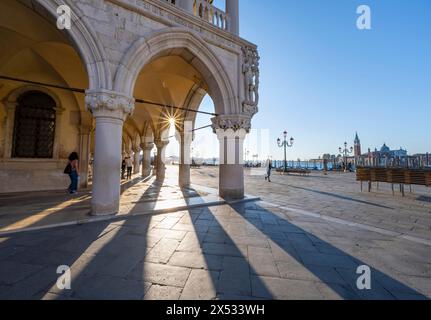 Kolonnade des Dogenpalastes mit Sonnenstern auf der Piazetta San Marco, Markusplatz, Venedig, Venetien, Italien Stockfoto