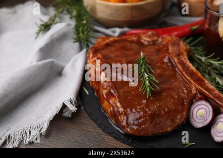 Leckeres mariniertes Fleisch, Rosmarin und Zwiebeln auf Holztisch, Nahaufnahme Stockfoto