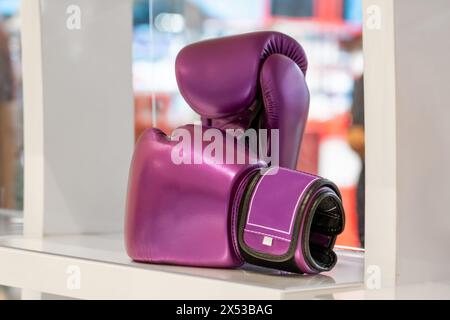 Lila Boxhandschuhe im Regal des Fightwear-Ladens. Boxhandschuhe werden im Sportgeschäft ausgestellt. Kampfladen, Boxausrüstung. Stockfoto