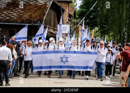 Besucher gehen im Marsch der Lebenden 2024 am Auschwitz Camp Gate „Work Makes You Free“, an dem 55 Holocaust-Überlebende teilnehmen. Holocaust-Überlebende und Überlebende des 7. Oktober nehmen zusammen mit einer Delegation unter anderem aus den Vereinigten Staaten, Kanada, Italien, Vereinigtes Königreich. Am Holocaust-Gedenktag im jüdischen Kalender (Yom HaShoah) marschieren Tausende von Teilnehmern schweigend von Auschwitz nach Birkenau. Der marsch hat einen Aufklärungs- und Erinnerungszweck. Der diesjährige Marsch wurde aufgrund des israelischen Krieges im besetzten Palästina stark politisiert. (Foto b Stockfoto