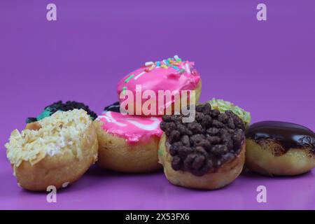 Donuts mit bunten Belag. Isolierter lila Hintergrund und Kopierbereich. Stockfoto