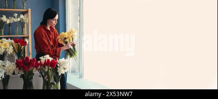 Kleine Unternehmen. Europäische Floristin, die Blumen im Blumengeschäft hält. Stockfoto