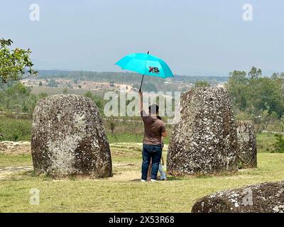 Phonsavan, Laos. April 2024. Touristen bewundern riesige Steinkrüge in der Ebene der Gläser, Site 1. Nur die Standorte 1, 2 und 3 sind für Besucher zugänglich. Die „Ebene der Gläser“ gilt als eine Art südostasiatischer Stonehenge und eine der rätselhaftesten archäologischen Stätten der Welt. Einige der Steinkrüge sind mehr als 2000 Jahre alt. Vermerk: Carola Frentzen/dpa/Alamy Live News Stockfoto