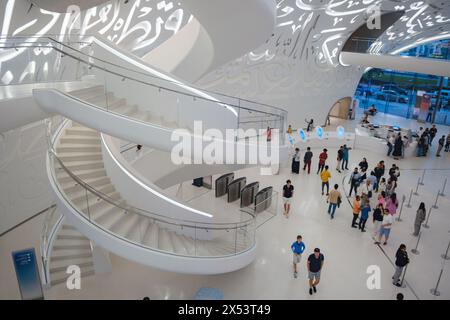 Dubai, VAE - 16. Januar 2024: Eintritt zum Museum der Zukunft, Innenraum der Eingangshalle mit Wendeltreppen und Touristen. Stockfoto