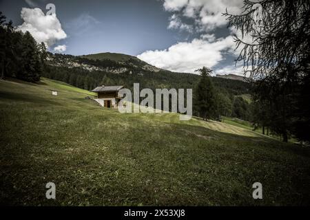 Einige alte Häuser über einer Alm in den Dolomiten mit wunderbarem Panorama Stockfoto