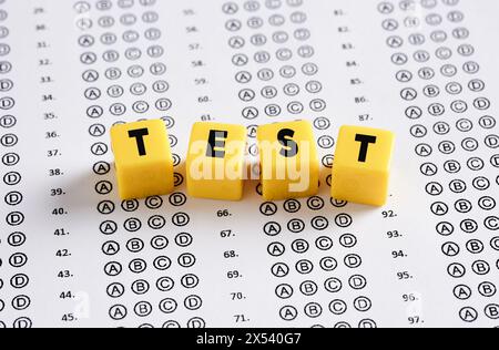 Prüfungspapier mit dem Wort Test auf gelben Würfeln. Konzepte für Bildung, Prüfung, Quiz und Schulerfolg. Stockfoto