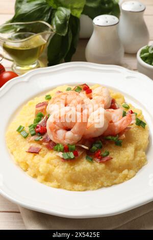 Teller mit frischen, leckeren Garnelen, Speck, Grütze, grüner Zwiebeln und Pfeffer auf dem Tisch, Nahaufnahme Stockfoto