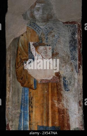 Fragmentarisches Fresko mit einem heiligen, wahrscheinlich Stephanus, auf dem Bogengesicht in der Chiesa di Santa Maria del Tiglio, einer komomomanischen Kirche, die in der zweiten Hälfte der 1100er Jahre in Gravedona in der Lombardei, Italien erbaut wurde. Stockfoto