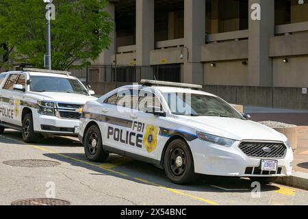 Washington DC, USA - 30. April 2024: Polizeipatrouillenwagen, die vom FBI benutzt wurden, parkten auf einer Straße vor dem Gebäude des J Edgar Hoover Hauptquartiers Stockfoto