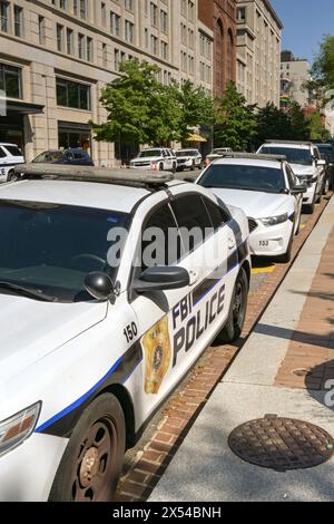 Washington DC, USA - 30. April 2024: Polizeipatrouillenwagen, die vom FBI benutzt wurden, parkten auf einer Straße vor dem Gebäude des J Edgar Hoover Hauptquartiers Stockfoto