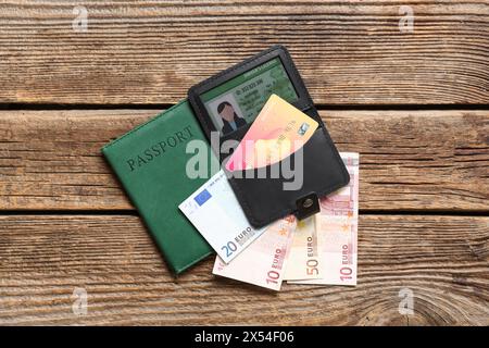 Komposition mit Karte in schwarzem Kreditkarteninhaber, Pass und Geld auf hölzernem Hintergrund Stockfoto