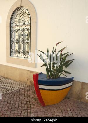 Großer dekorativer, handbemalter Übertopf in Form eines Bootes im Zentrum von Olhão Südportugal, der das starke Fischererbe dieser kleinen Stadt feiert Stockfoto