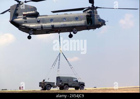 RAF Chinook HC.2 ZH894 mit einer unterirdischen Kombination von Land Rover und Anhänger während einer taktischen Show auf der Biggin Hill Air Show im Juni 2010. Stockfoto