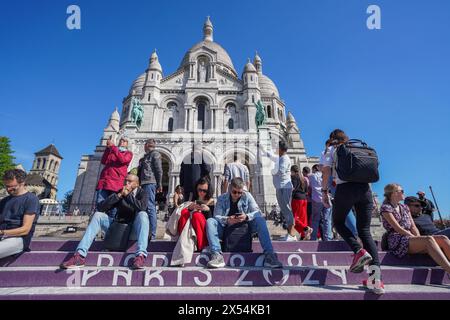 Paris, Frankreich. Mai 2024. Touristen genießen die warme Frühlingssonne auf den gemalten Stufen für die olympischen Spiele in der Basilika Sacré-Cœur de Montmartre in Paris. Quelle: amer Gazzal/Alamy Live News Stockfoto