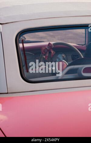 Rosafarbener Nissan Figaro mit Ohren und Schleife am Lenkrad in den Straßen Londons Stockfoto