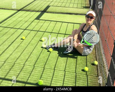 Frauen, die Ball servieren. Junge Erwachsene Mädchen spielen Tennis vor der Arena. Person Racket Beat Game Club. People Group hat das Spiel auf dem Sportplatz getroffen. Pflege der Passform Stockfoto