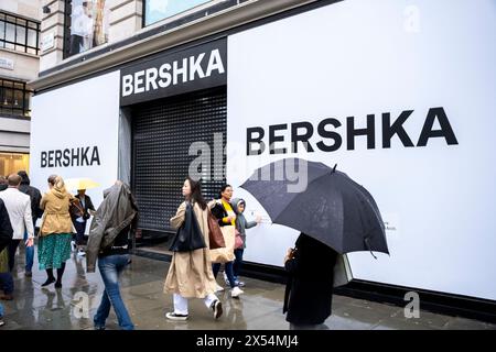 Der Regen an Feiertagen am Montag entmutigt nicht die vielen Käufer und Besucher auf der Oxford Street, die dem schlechten Wetter trotzen und am neuen Bershka Store vorbeikommen, der derzeit am 6. Mai 2024 in London renoviert wird. Die Oxford Street ist ein bedeutendes Einkaufszentrum im West End der Hauptstadt und ist Europas geschäftigste Einkaufsstraße mit rund einer halben Million Besuchern der rund 300 Geschäfte, von denen die meisten Mode- und High Street-Bekleidungsgeschäfte sind. Stockfoto