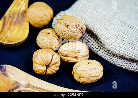 Walnuss (Juglans regia), Walnüsse mit Beutel und Holzlöffel Stockfoto