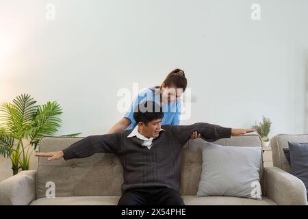 Ältere asiatische Männer-Physiotherapie mit Unterstützung von Krankenschwester oder Pflegekraft. Älterer Mann, der Übungen für Patienten mit Pflegepersonen in der häuslichen Krankenpflege macht Stockfoto