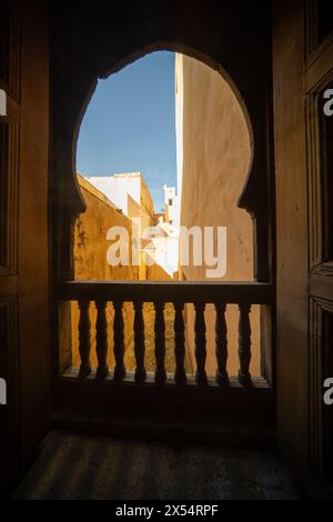 Ein ruhiger Blick fängt das Wesen von Fès durch das verzierte Fenster von Cherratine Madrasa ein. Fès, Marokko. Stockfoto