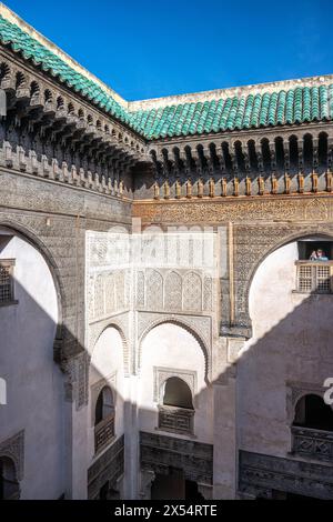 Ein ruhiger Blick fängt das Wesen von Fès durch das verzierte Fenster von Cherratine Madrasa ein. Fès, Marokko. Stockfoto