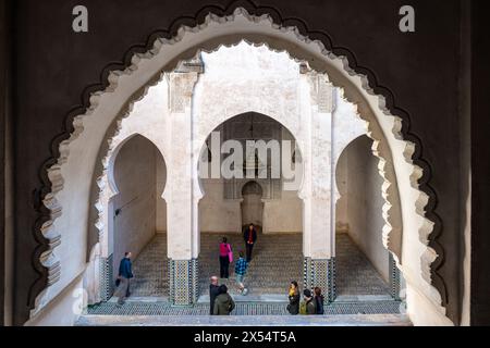 Ein ruhiger Blick fängt das Wesen von Fès durch das verzierte Fenster von Cherratine Madrasa ein. Fès, Marokko. Stockfoto