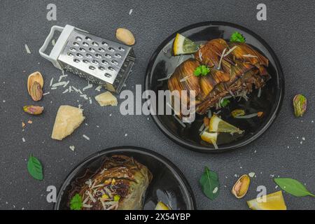 Köstliche gebackene Artischocke mit Parmesankäse und Pistazien. Olivenöl, Knoblauch, Petersilie und Zitrone. Schwarzer hölzerner Hintergrund, bereit für veganes Essen, Stockfoto